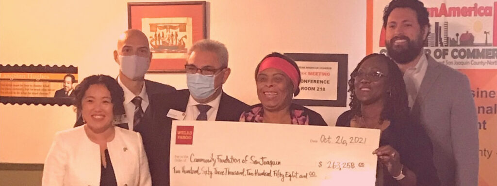 Leaders of the African American Chamber of Commerce of San Joaquin hold a large check from Wells Fargo